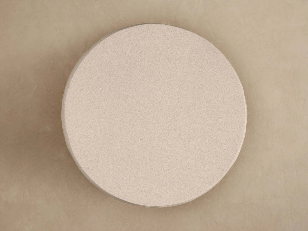 Close-up of Eden Outdoor End Table. Light beige, textured top surface and curved side with distinct horizontal raked ribs.