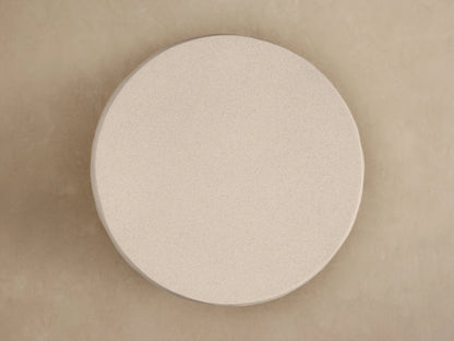 Close-up of Eden Outdoor End Table. Light beige, textured top surface and curved side with distinct horizontal raked ribs.
