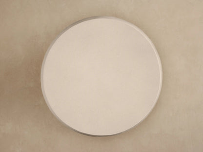 Close-up of Eden Outdoor Round Coffee Table, light beige, with smooth top surface & horizontally ribbed, textured sides.