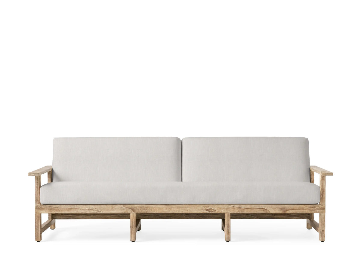 Front view of the Starboard Snow Emmons Outdoor Sofa with light white cushions and a natural teak wood frame.
