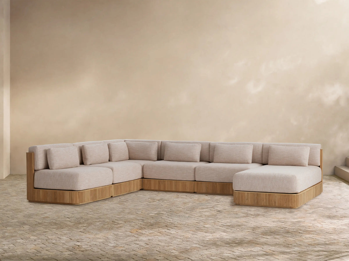 Front view of the Beaumont‚Ñ¢ Outdoor Teak Six-Piece Sectional with Chaise, featuring a slatted teak frame and light beige cushions.