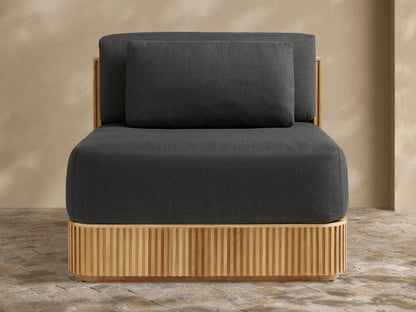 Beaumont Outdoor Teak Lounge Chair in Rosemount Graphite. Front-right view of dark grey cushions on a slatted light teak wood base.