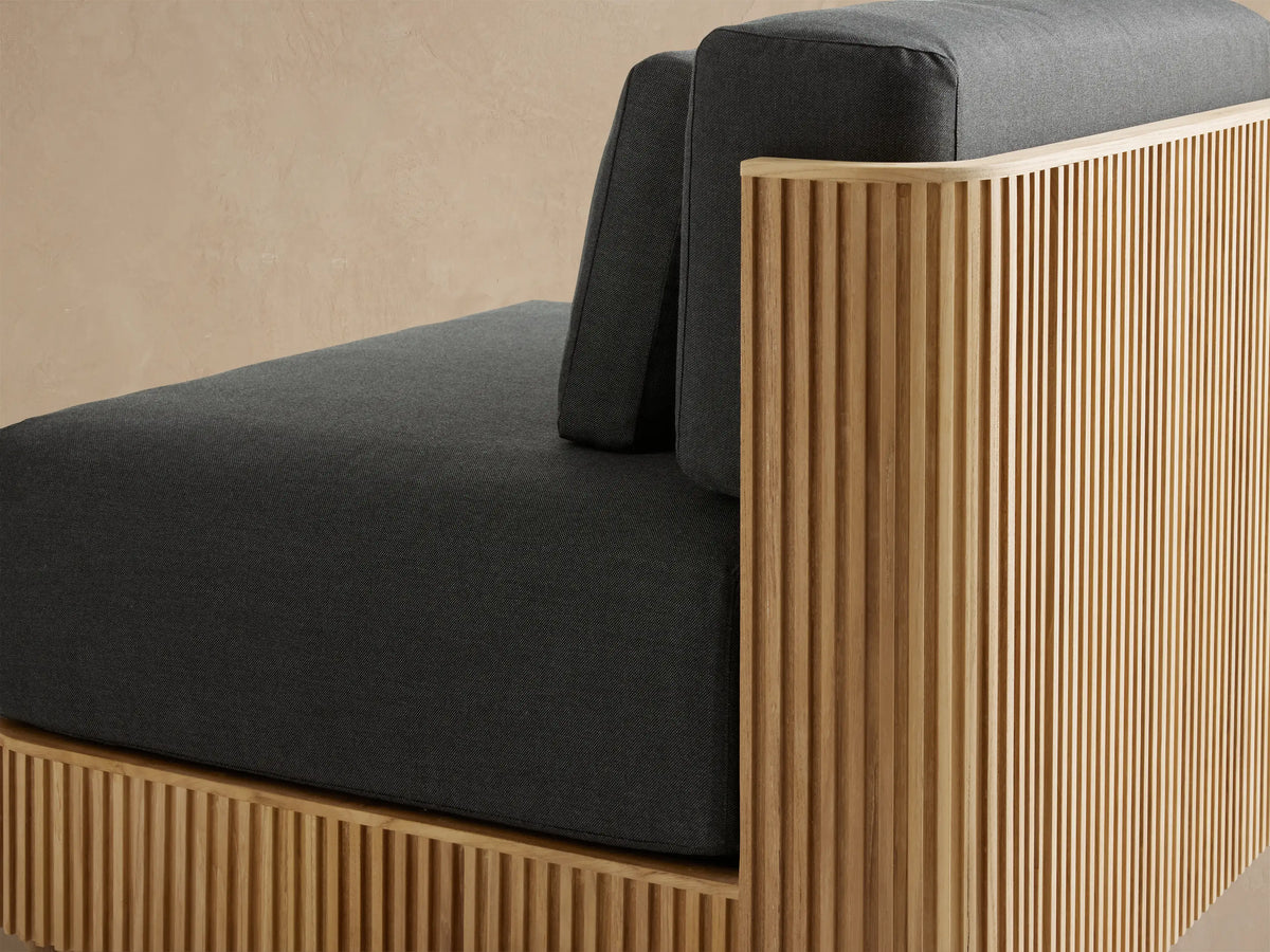 Front view of Beaumont Outdoor Teak Lounge Chair. Dark gray Rosemount Graphite cushions atop a slatted natural teak wood base.