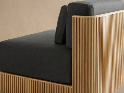 Front view of Beaumont Outdoor Teak Lounge Chair. Dark gray Rosemount Graphite cushions atop a slatted natural teak wood base.
