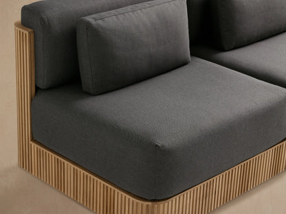 Front view of Beaumont Outdoor Teak Two-Piece Modular Sofa with dark gray cushions, natural slatted teak wood base.