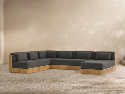 Beaumont Outdoor Teak Six-Piece Sectional with Chaise. Dark grey cushions on a light wooden slatted base.