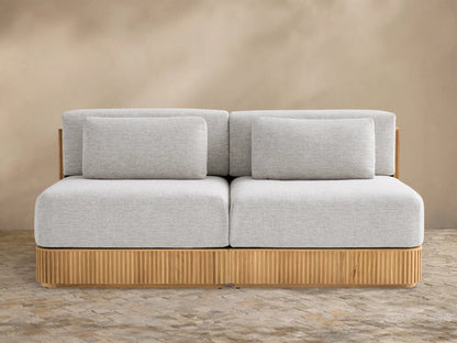 Beaumont Outdoor Teak Two-Piece Modular Sofa with light gray cushions on a natural teak wood base with vertical slats.