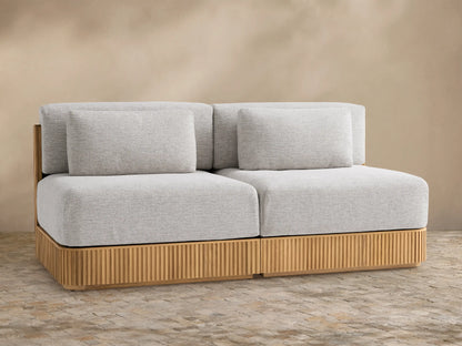 Beaumont Outdoor Teak Two-Piece Modular Sofa with light gray cushions on a natural teak wood base with vertical slats.