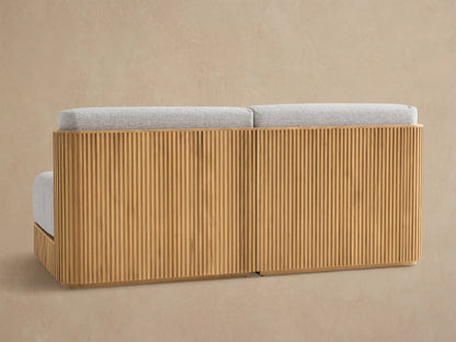 Close-up of Beaumont Outdoor Teak Sofa, showing light grey textured cushions and natural slatted teak wood frame.