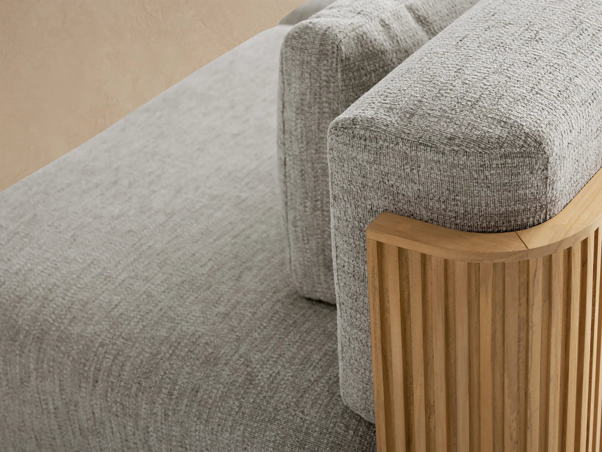 Beaumont Outdoor Teak Three-Piece Modular Sofa with light grey cushions and a slatted natural teak wood base, against a soft beige wall.