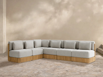 Beaumont Outdoor Teak Six-Piece Sectional, L-shaped, with light gray cushions and a fluted teak wood base on a patio.