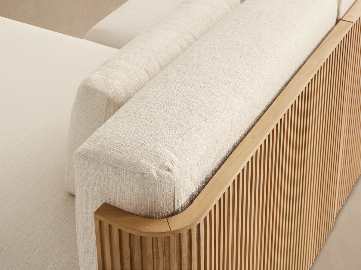 Beaumont outdoor 4-piece double chaise sectional with natural slatted teak base, cream cushions, on a light stone patio.