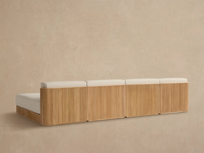 Close-up of Beaumont Outdoor Sectional, showing natural teak wood frame with vertical slats and light cream textured cushions.