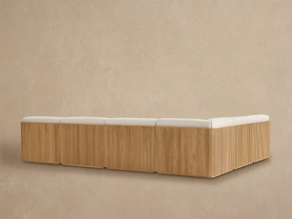 Close-up of Beaumont Outdoor Teak Sectional corner. Natural teak frame with vertical slats and textured light beige cushions.