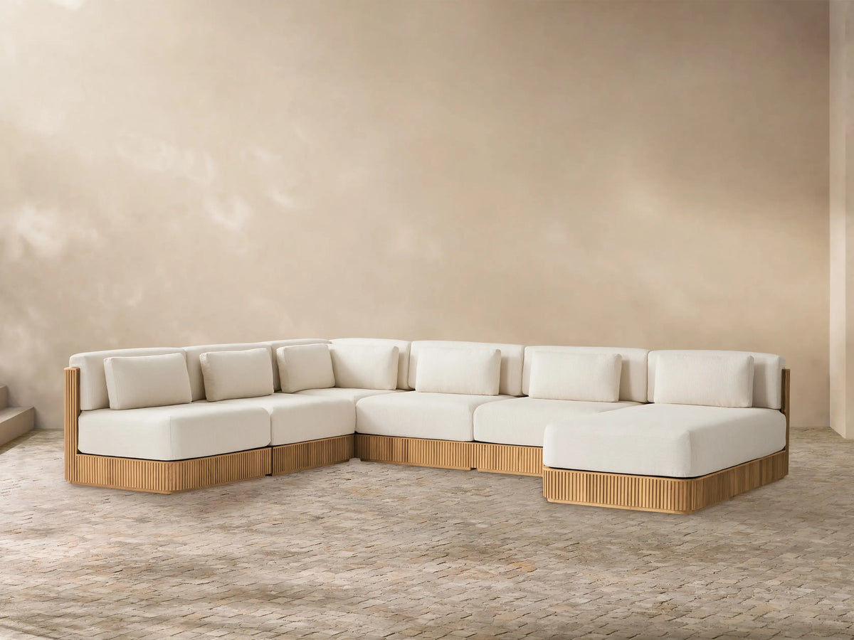 Front view of the Beaumont Outdoor Teak Six-Piece Sectional with Chaise, showing cream cushions and slatted teak base.