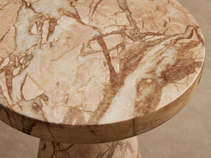 Fira Outdoor End Table: round top, conical base, light brown marble-like finish with dark veining, on stone tiles.