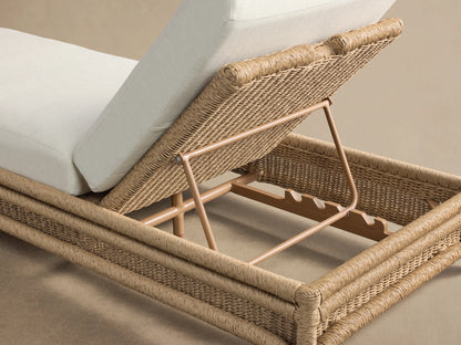 Fowler Outdoor Chaise, side view. Light brown handwoven all-weather wicker base with inclined cream cushions.
