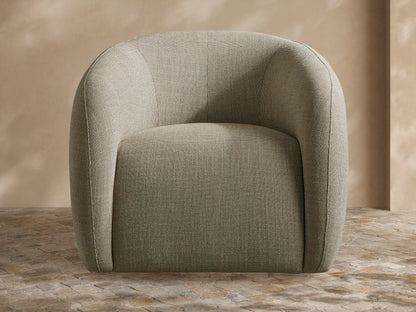Tan Fresno Outdoor Swivel Chair with curved upholstered back and a light beige throw blanket in an outdoor patio.
