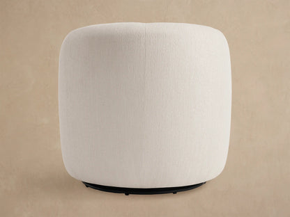 Close-up of the off-white textured upholstery on the curved back and seat of a Fresno Outdoor Swivel Chair, against a beige wall.