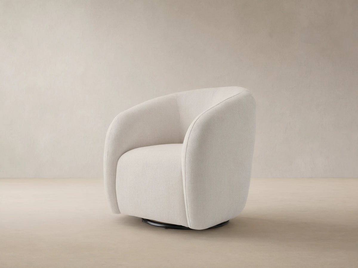 Fresno Outdoor Swivel Chair, off-white textured upholstery, rounded shape, black swivel base, on a rustic tiled floor.