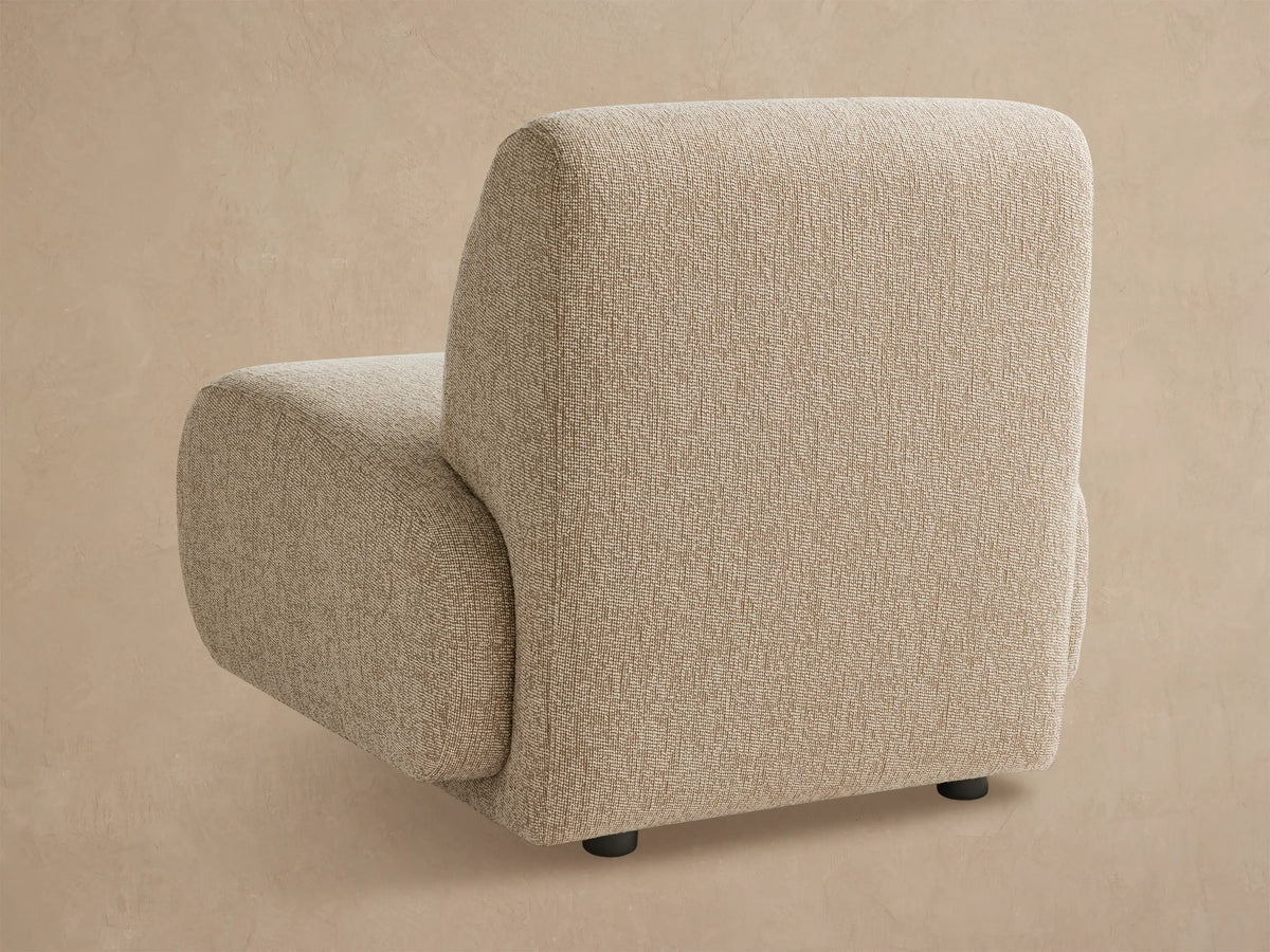 Front view of a modern Gianni Outdoor Lounge Chair in light beige textured fabric with rounded cushions, on a tiled floor.