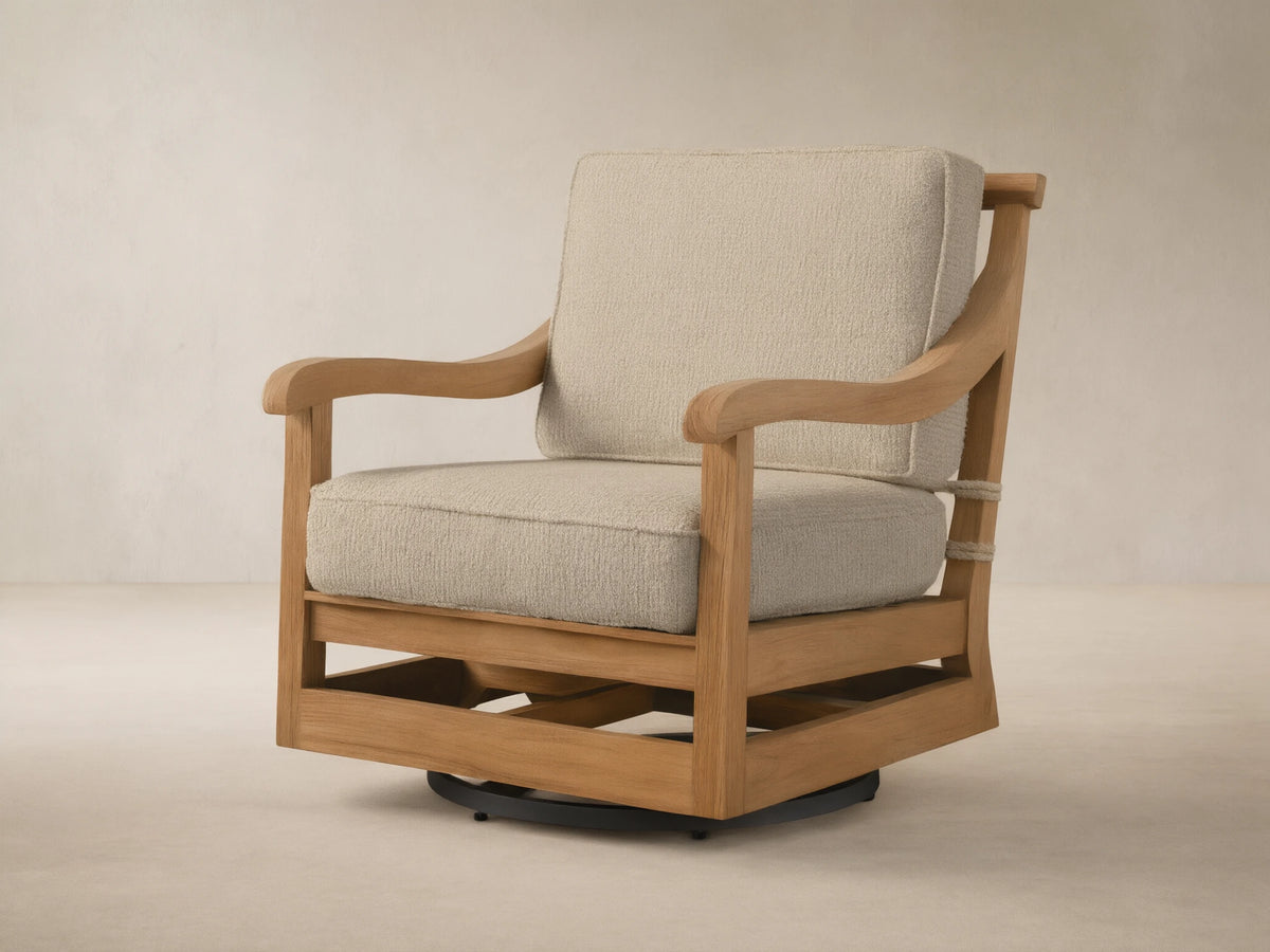 Hamptons Outdoor Swivel Chair in weathered fawn teak with light beige cushions, angled on an outdoor patio setting.