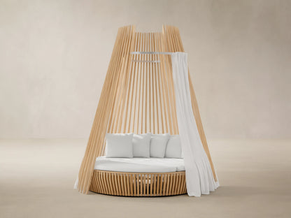 Outdoor hut with white water-repellent replacement cushions on a white patio. Blue sky and sea with islands in background.