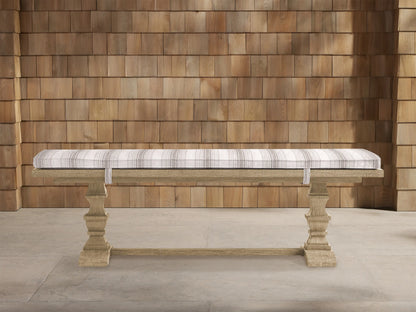Hamptons Outdoor Dining Bench in weathered fawn teak, with a light grey striped cushion, against a wooden shingle wall.