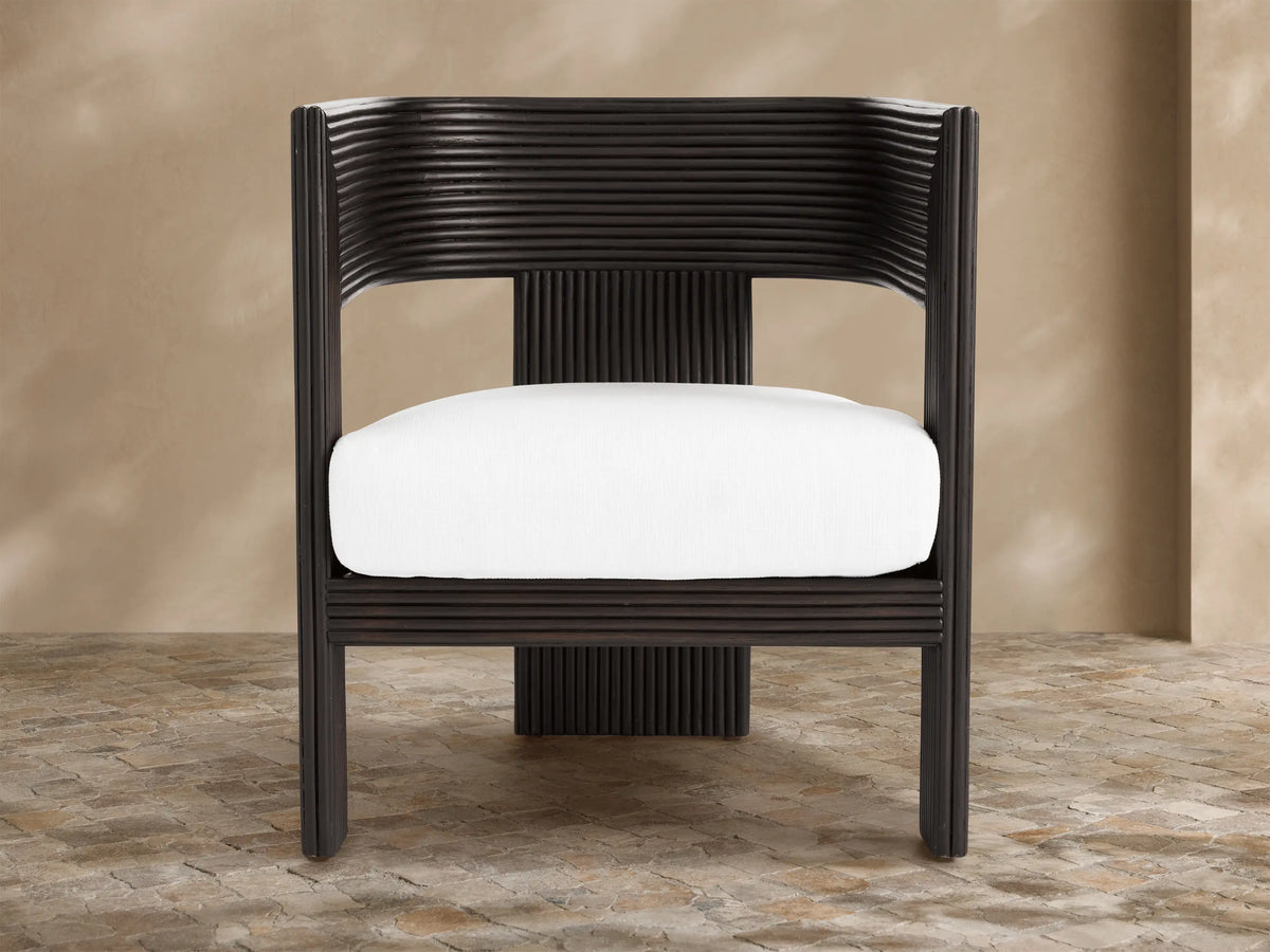 White Ilia Outdoor Water-Repellent Replacement Cushion in dark brown ribbed chair, front view, on tiled floor.