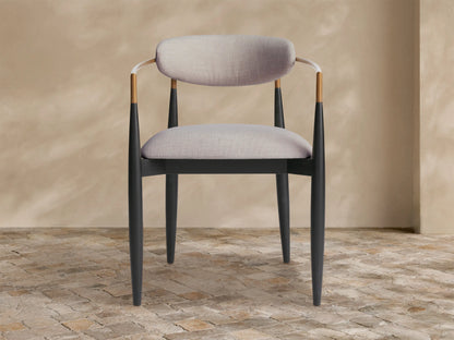 Jagger Outdoor Dining Arm Chair with black wooden frame, light grey cushions, and bronze-toned metal armrests, angled view.