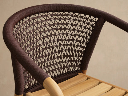 Kaia Outdoor Dining Chair with a natural teak wood frame and dark brown intricately woven rope back. Seen straight on, no cushion.