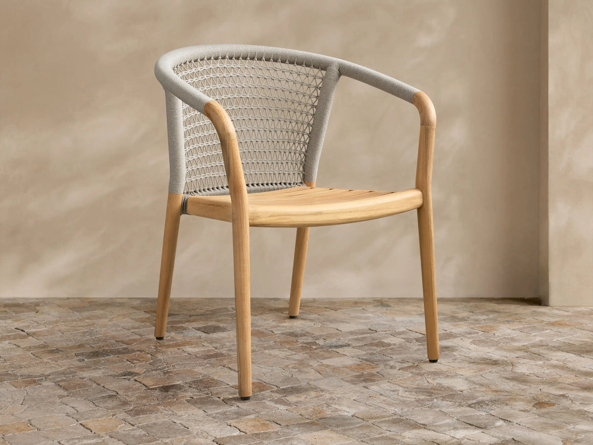 Front view of the Kaia Outdoor Dining Chair with Cushion, featuring a natural teak wood frame and light gray woven back.