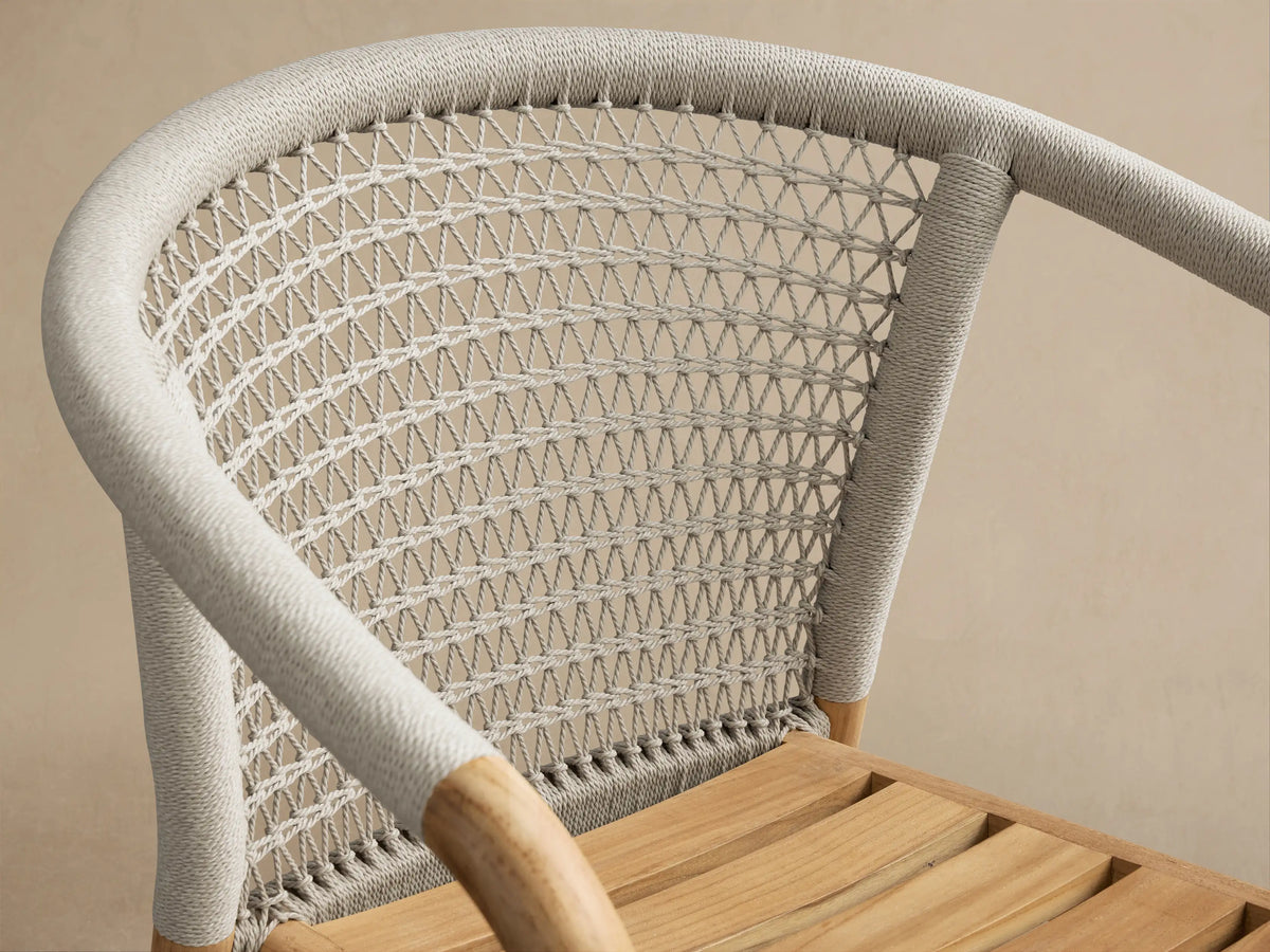 Natural Teak Kaia Outdoor Dining Chairs with white handwoven rope detail, stacked side view.