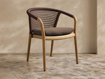 View of stacked Kaia Outdoor Dining Chair with Cushion, featuring natural teak wood frames, brown woven backrests, and armrests.