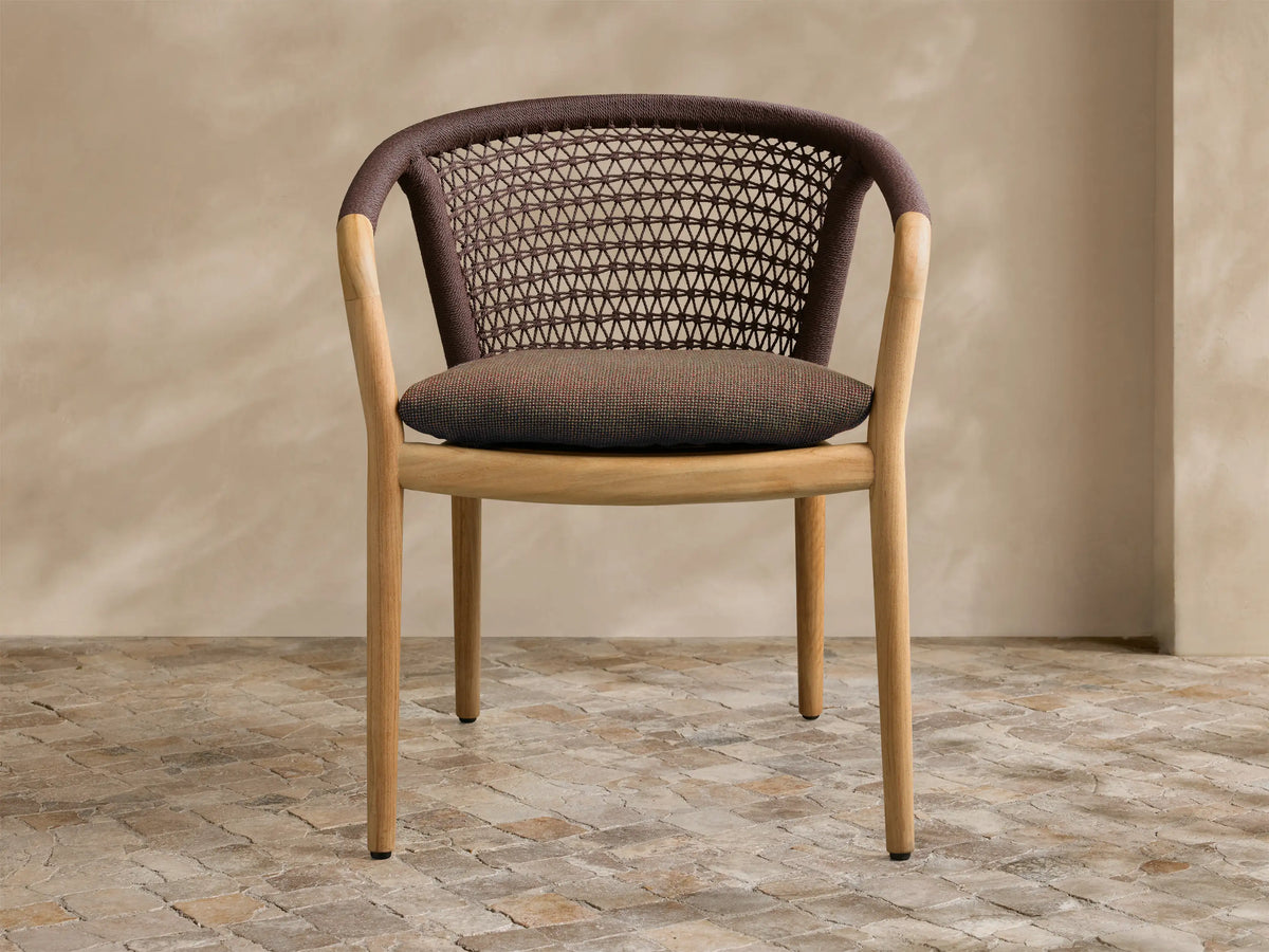 Rear view of the Kaia Outdoor Dining Chair with Cushion, featuring a brown woven back, taupe cushion, and natural teak frame.