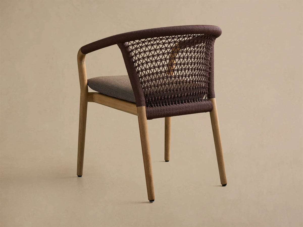 Rear view of Kaia Outdoor Dining Chair with Cushion. Dark brown woven back and armrests, gray cushion, natural teak wood frame.