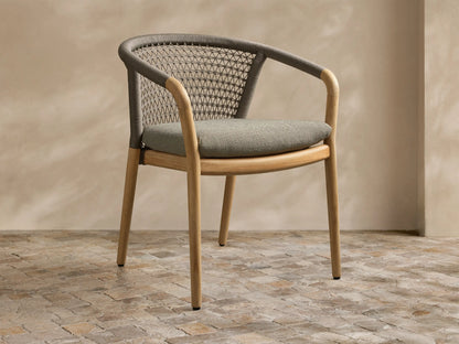 Front-side view of a Kaia Outdoor Dining Chair with Cushion, with natural teak wood frame, gray woven rope back, and light gray cushion.