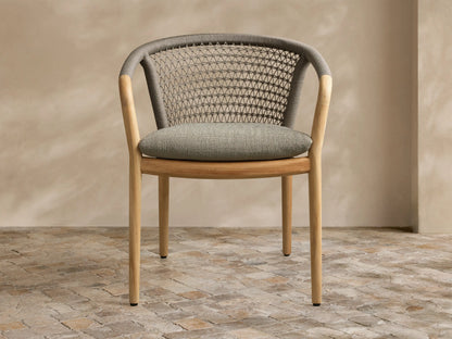 Side profile of three stacked Kaia Outdoor Dining Chairs with Cushion, featuring gray Performance Weave polyester rope backs and natural teak wood frames.