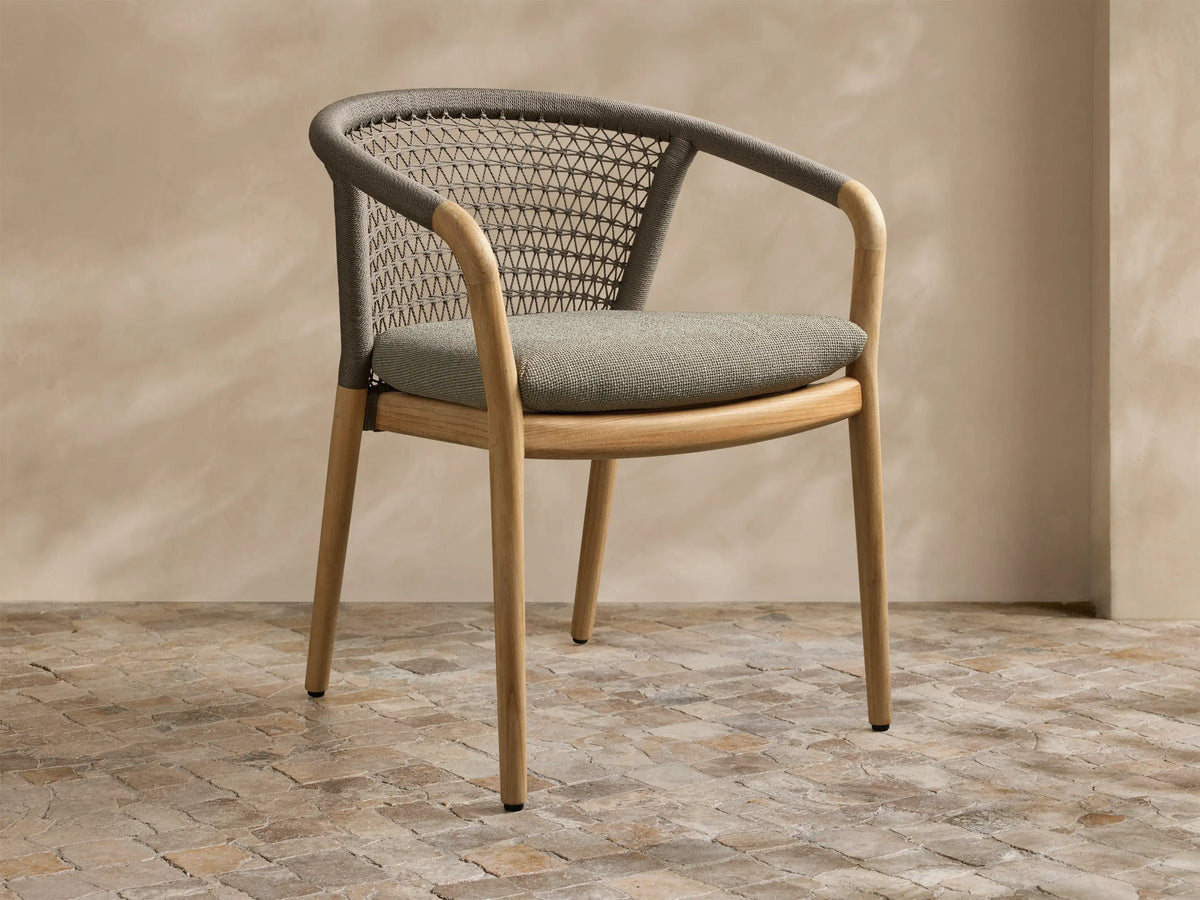 Front view of the Kaia Outdoor Dining Chair with Cushion, featuring a natural teak wood frame, grey woven back, and light grey cushion.