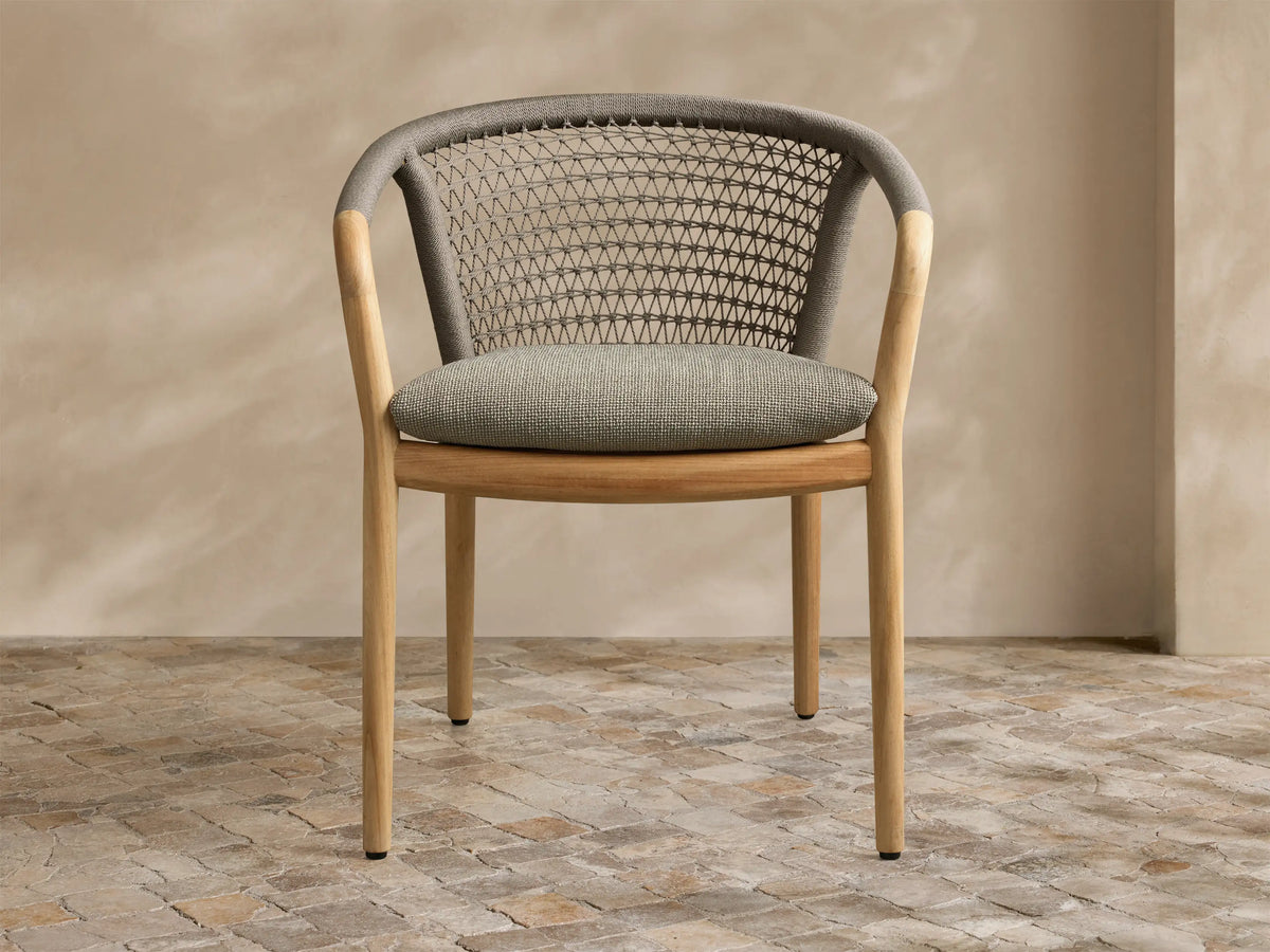 Front view of the Kaia Outdoor Dining Chair with Cushion, featuring a natural teak wood frame, grey woven back, and light grey cushion.