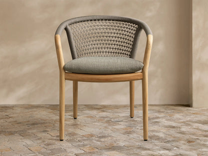 Front view of the Kaia Outdoor Dining Chair with Cushion, featuring a natural teak wood frame, grey woven back, and light grey cushion.