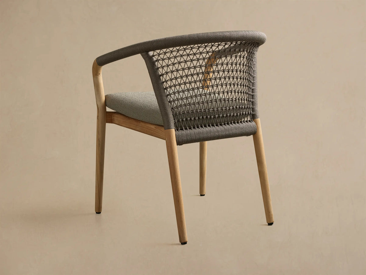 Close-up view of the gray Kaia Outdoor Dining Chair with Cushion, featuring an intricately handwoven rope backrest and a light gray fabric cushion.