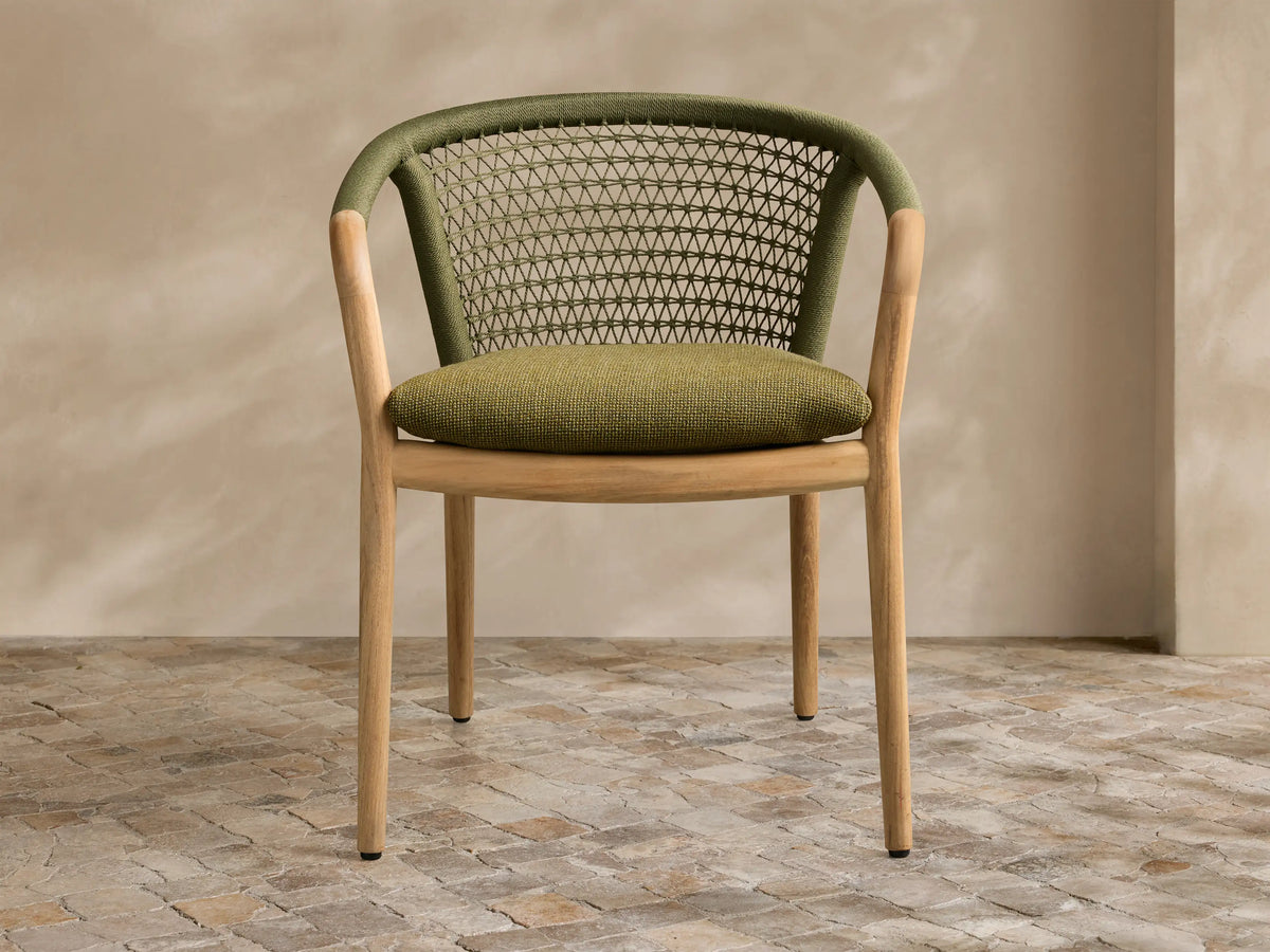 Front view of the green Kaia Outdoor Dining Chair with Cushion, featuring a natural teak wood frame and intricate woven back.