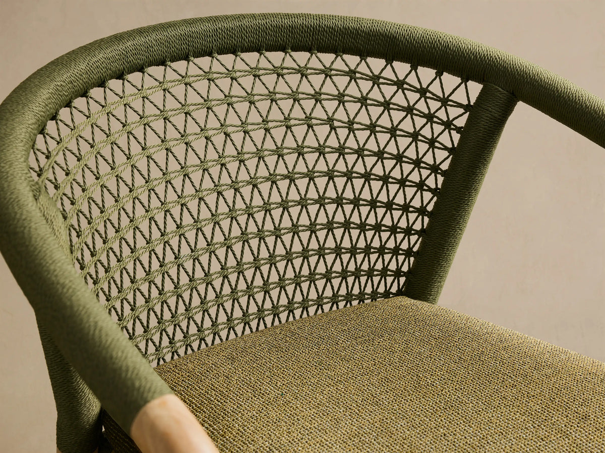 Close-up of the olive green handwoven rope back and moss green textured cushion of the Kaia Outdoor Dining Chair with Cushion.