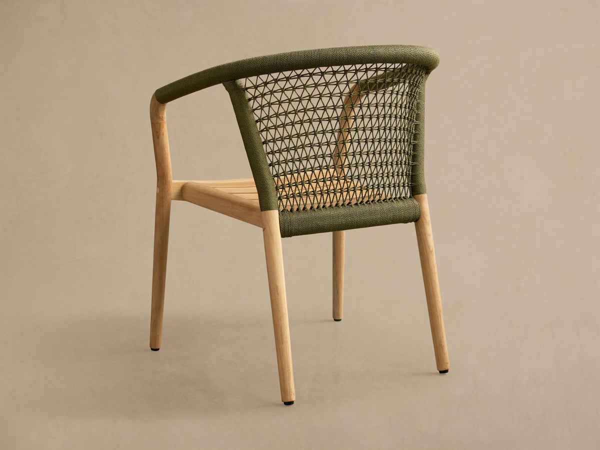 Rear view of a Kaia Outdoor Dining Chair with Cushion, featuring a natural teak wood frame and an olive green woven polyester rope backrest.