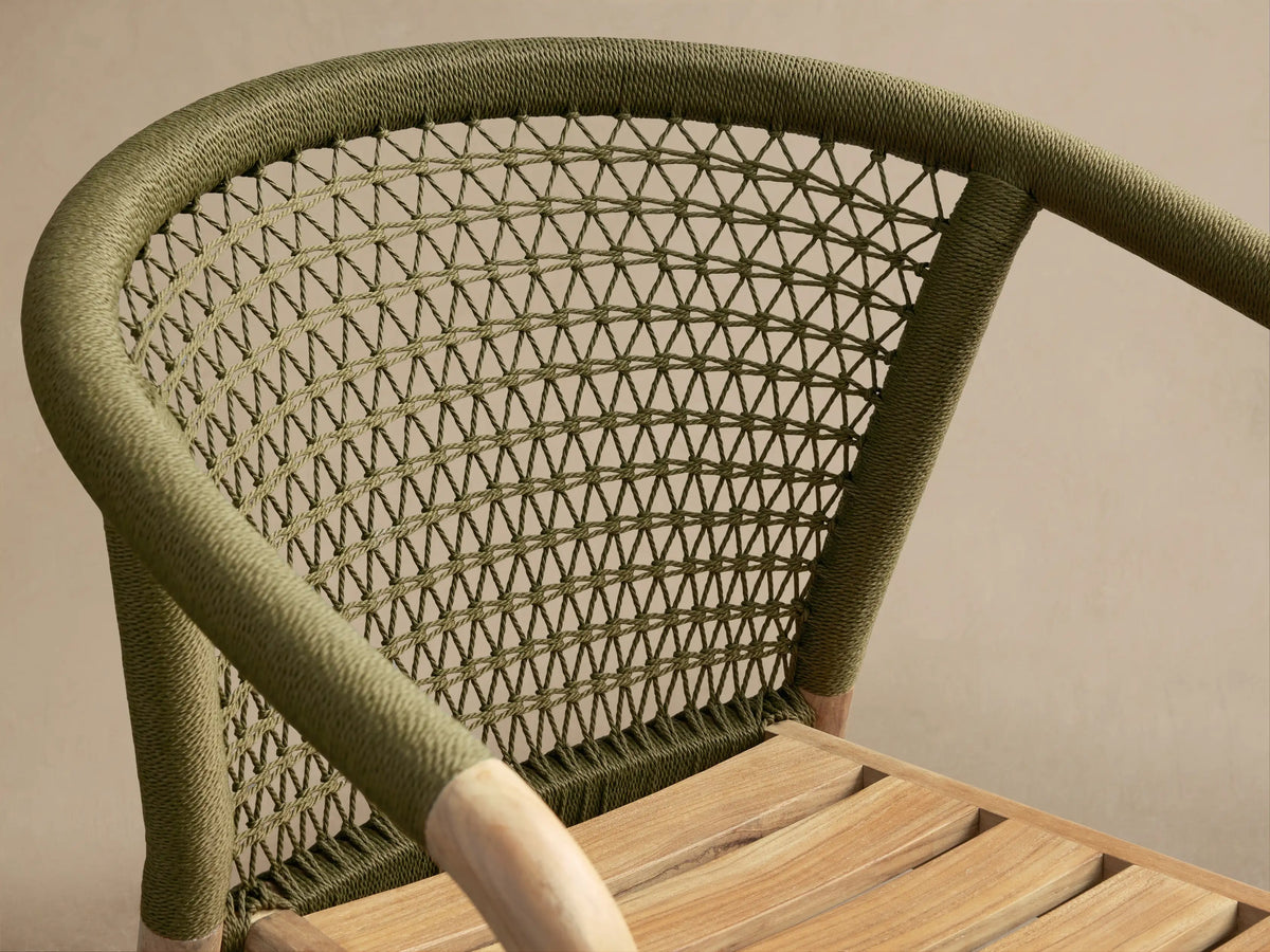 Close-up of the olive green woven back and natural teak slatted seat of the Kaia Outdoor Dining Chair with Cushion.