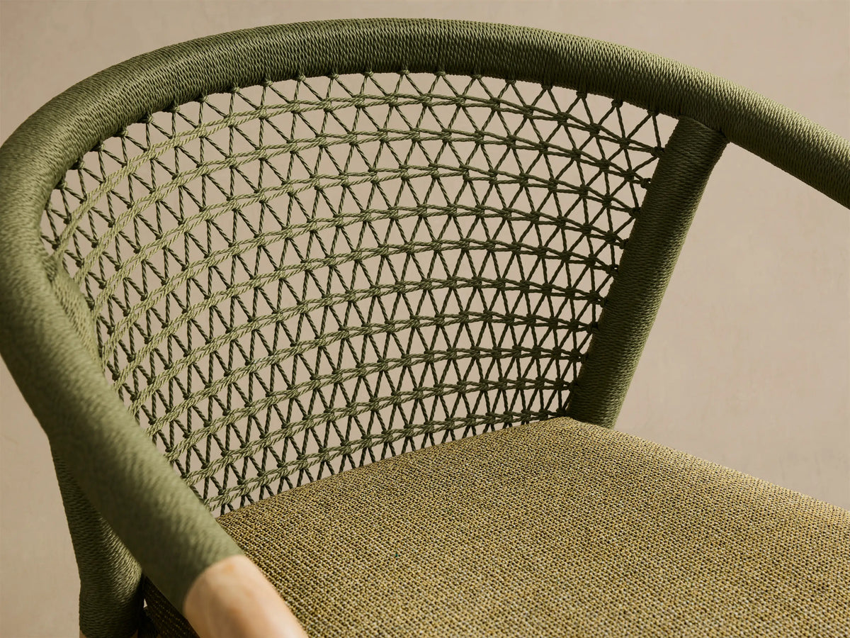 Front view of the Kaia Outdoor Dining Chair with Cushion. Natural teak frame, olive green woven back and arms, and olive green cushion.