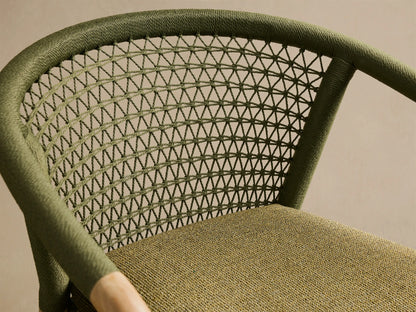 Front view of the Kaia Outdoor Dining Chair with Cushion. Natural teak frame, olive green woven back and arms, and olive green cushion.