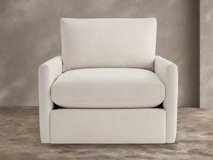 Kipton Outdoor Swivel Chair in cream fabric, front-facing, with plush seat/back cushions, on stone patio.