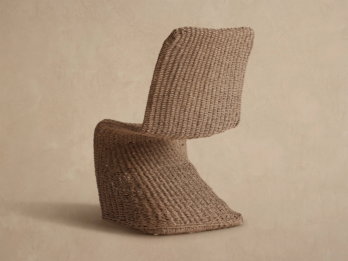 Close-up of a Leon Outdoor Dining Chair, showing its natural light beige handwoven all-weather resin wicker seat and back.